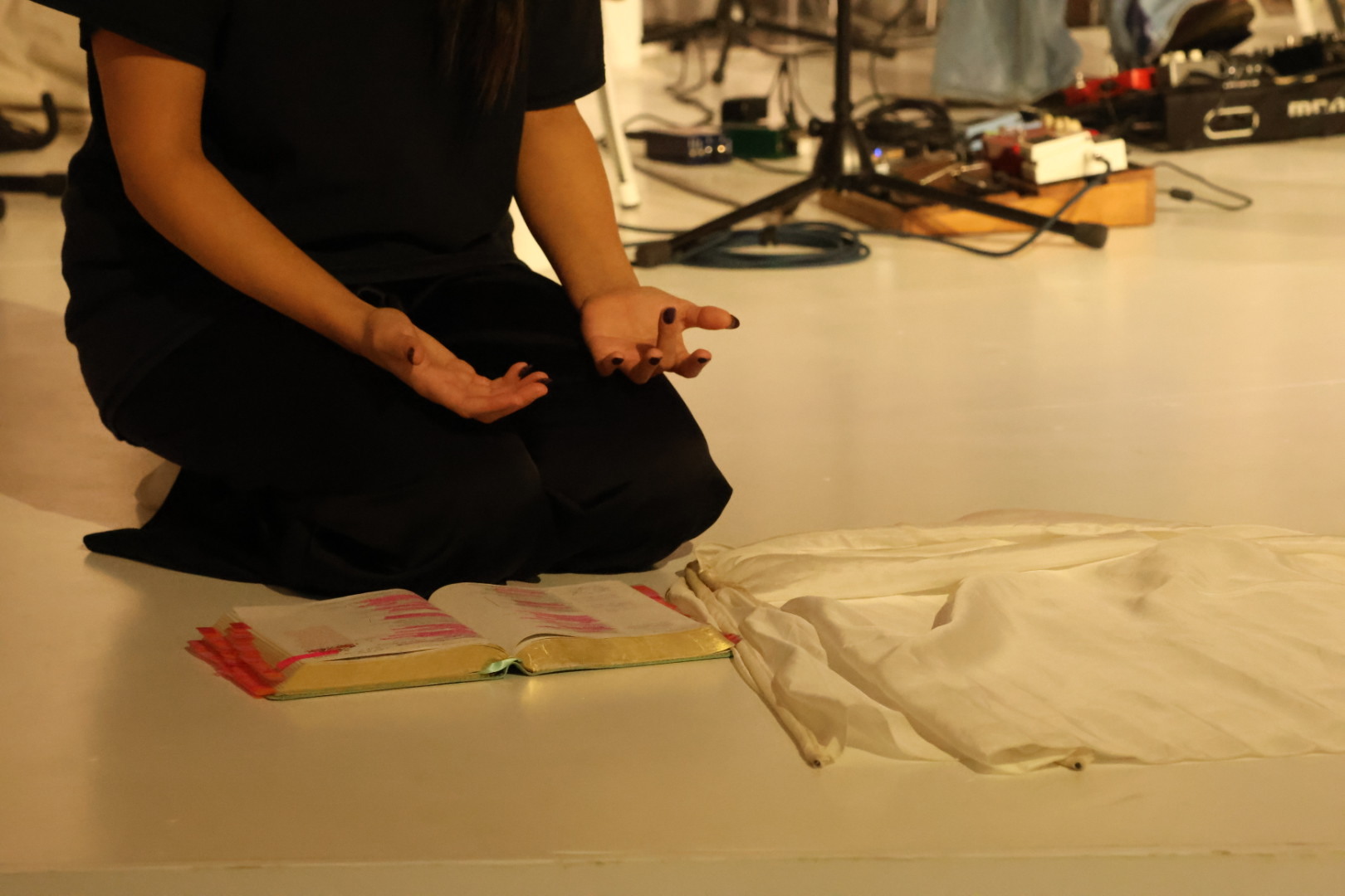 A worshipper kneeling in prayer beside an open Bible